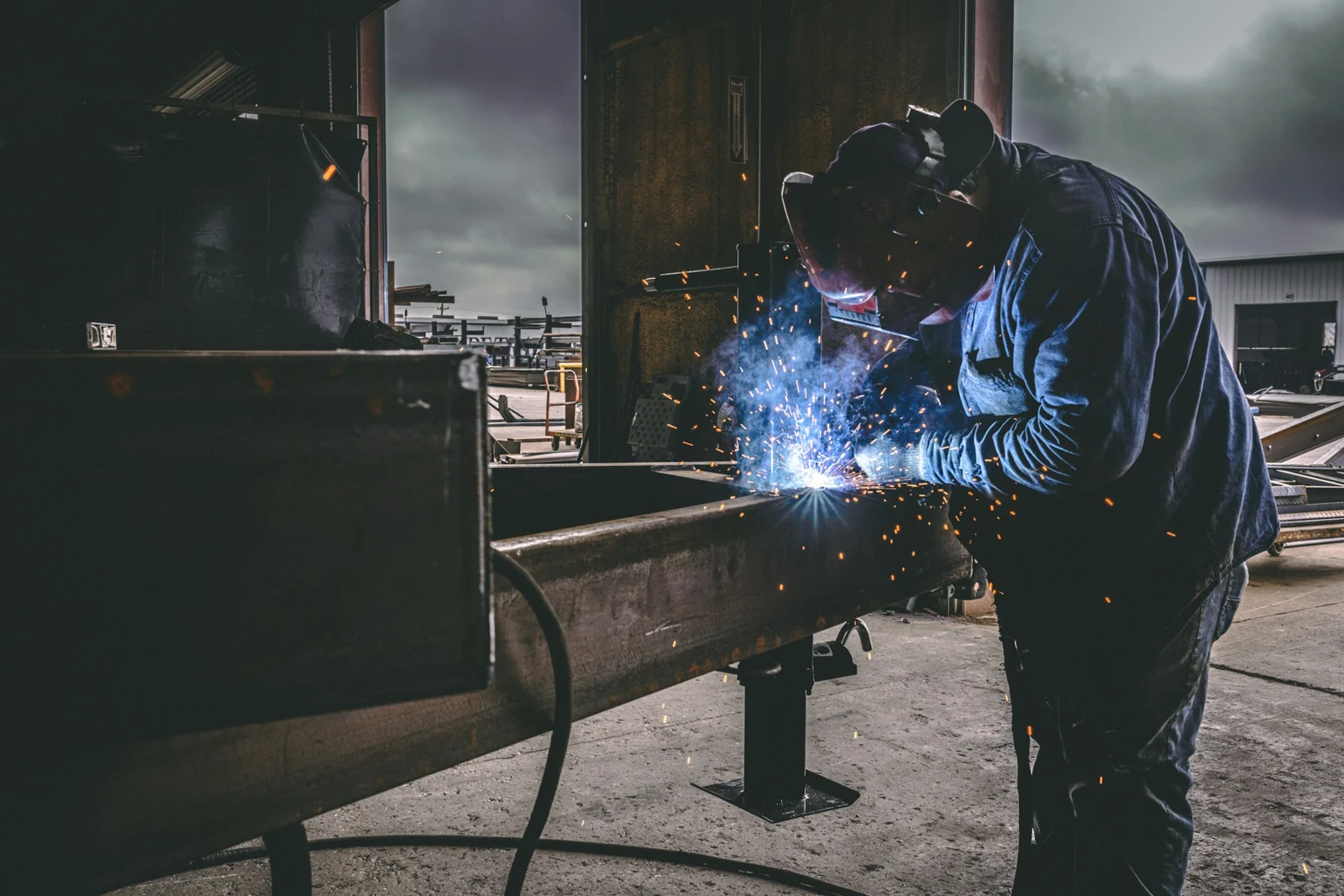 Welder joining metal in an industrial workshop